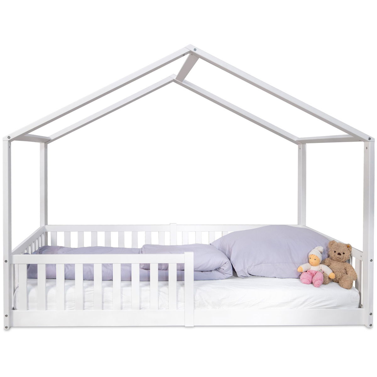 Weisses Kinderbett in Hausoptik mit Kissen und Kuscheltieren