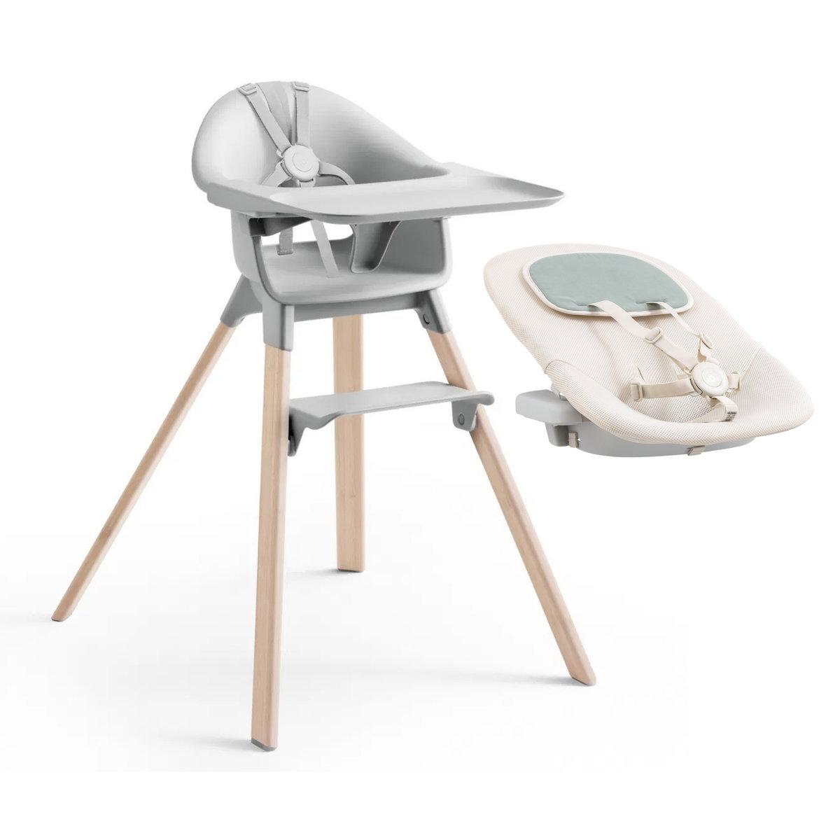 Ein moderner Hochstuhl mit grauem Sitz, Holzbeinen und Fussst&uuml;tze sowie ein beiger Babysitzaufsatz mit Anschnallgurt, beides nebeneinander auf weissem Hintergrund.